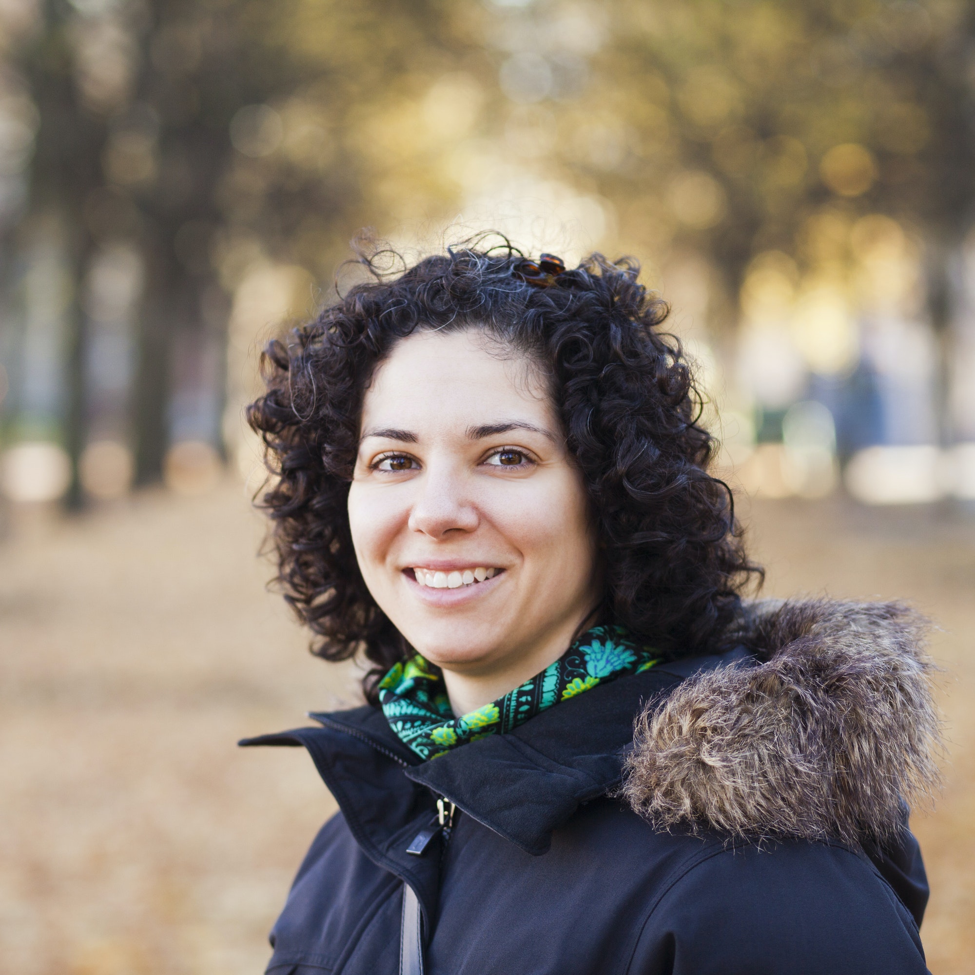 A woman in a black jacket standing on the ground.